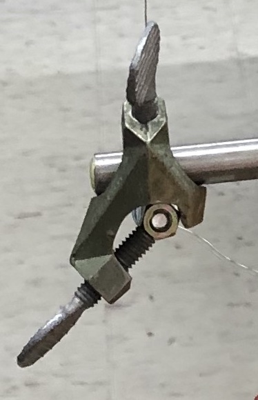 screw_from_right_angle_clamp_tightened_onto_nuts.jpeg